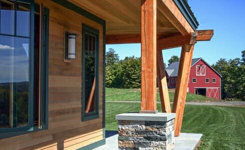 Exterior beams with stone post bases on the porch of the Night Pasture Farm in Chelsea, VT