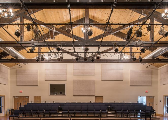 Timber Trusses with steel plates and mounted stage lights in a performance space in the Hopkinton Art Center