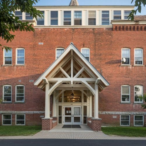 White Entry Canopy with king post trusses at Fuller Hall at the Vermont Academy school made with douglas fir