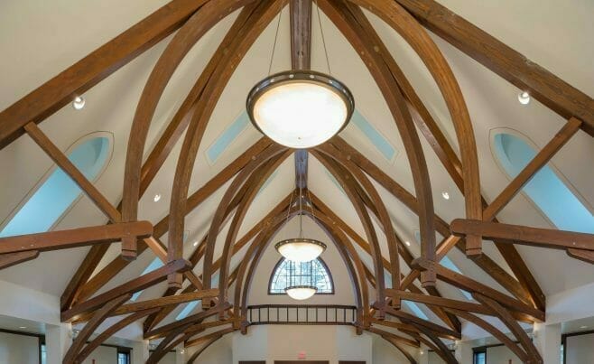 Finials on dark stained timber frame arches in a church sanctuary