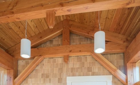 Douglas fir beams and trusses against a wood clad wall in the Port Society Complex