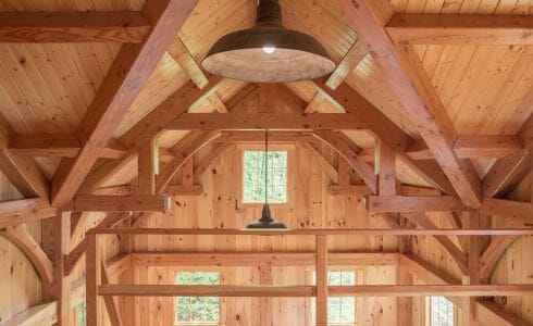Loft area with heavy timber trusses in the Ox Hill Barn that overlooks the Cathedral Ceilings and windows in the Ox Hill Barn