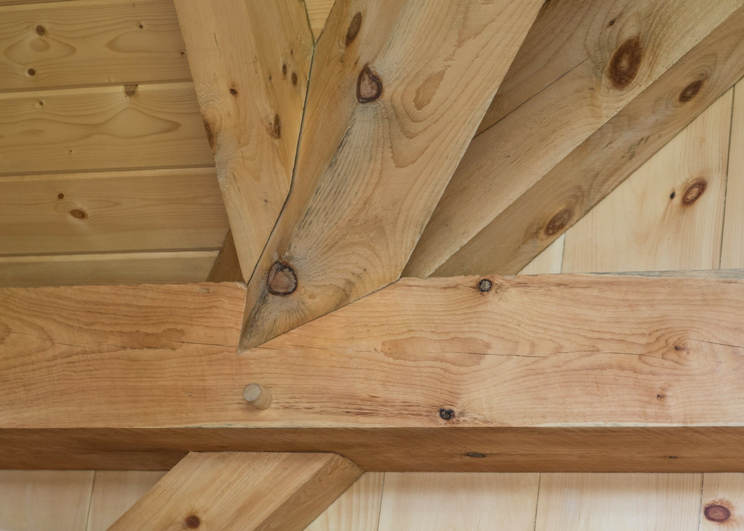 Complex joinery in a timber frame workout room made from rough sawn white pine