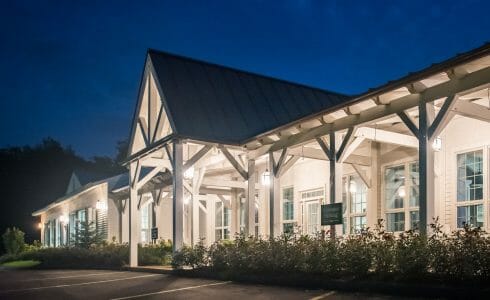 The VTel porch with post, beams, and king post trusses, has been fabricated with planed Douglas fir and painted white.