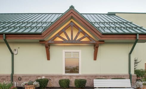 Heavy Timber Porte Cochere Entry Way at the Oxford Casino in Maine with King post trusses in White Pine with steel plates. Above window King Truss Dormers.