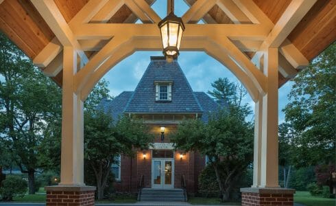 White Entry Canopy with king post trusses at Fuller Hall at the Vermont Academy school made with douglas fir