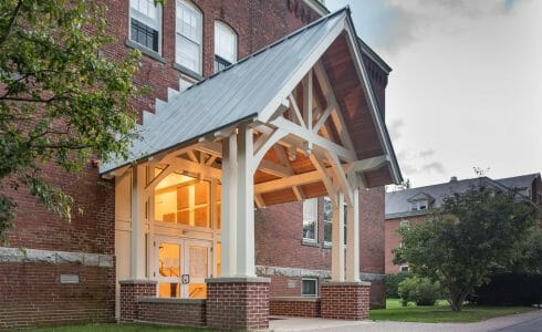 White Entry Canopy with king post trusses at Fuller Hall at the Vermont Academy school made with douglas fir
