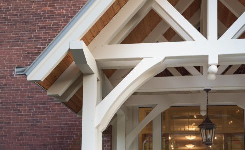 White Entry Canopy with king post trusses at Fuller Hall at the Vermont Academy school made with douglas fir