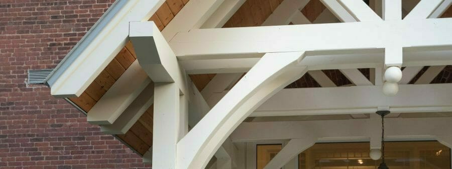 White Entry Canopy with king post trusses at Fuller Hall at the Vermont Academy school made with douglas fir