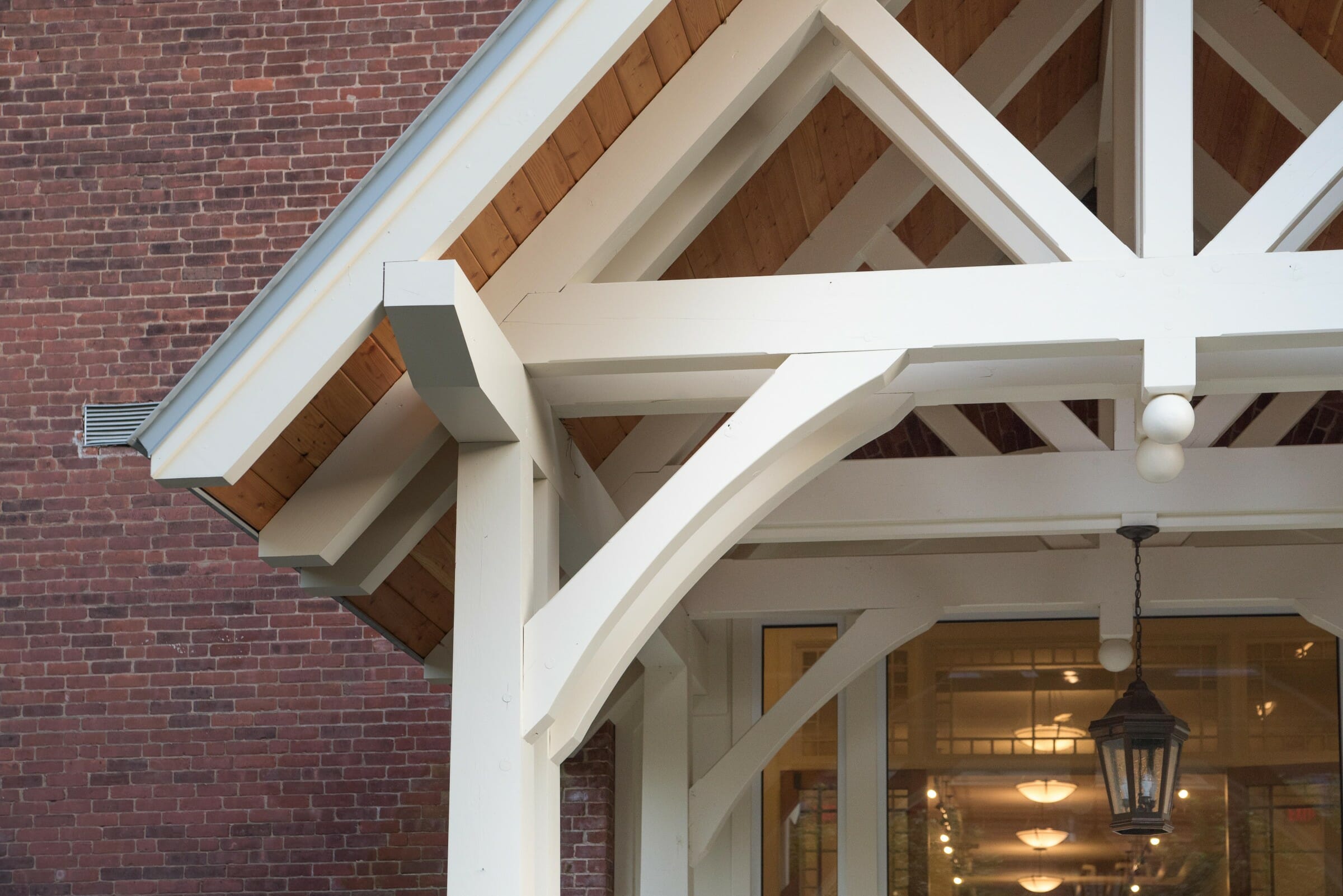 White Entry Canopy with king post trusses at Fuller Hall at the Vermont Academy school made with douglas fir