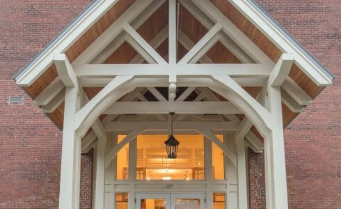 White Entry Canopy with king post trusses at Fuller Hall at the Vermont Academy school made with douglas fir