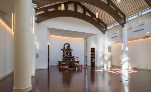 The Buddha statue in the Mahamudra Buddhist Center sits peacefully in the main hall with Timber Arches overhead