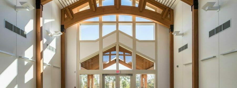 Interior of Mahamudra Buddhist retreat with high ceilings and glulam arches.