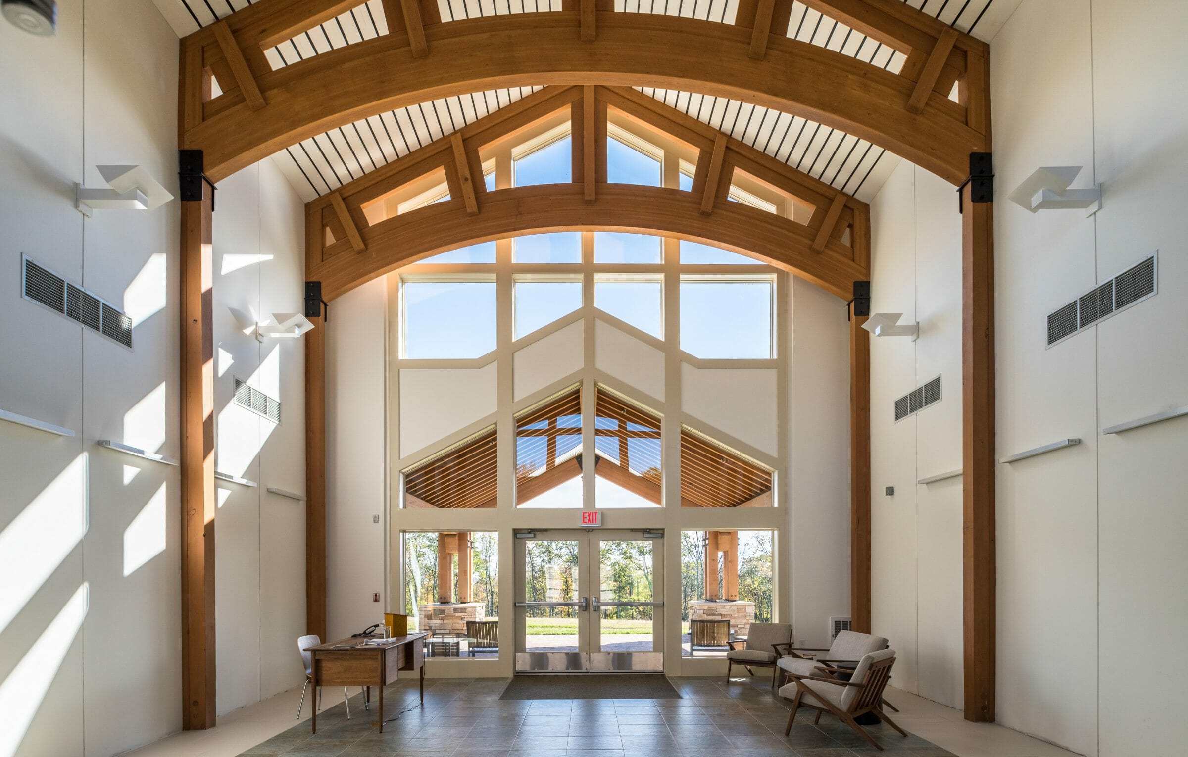 Interior of Mahamudra Buddhist retreat with high ceilings and glulam arches.