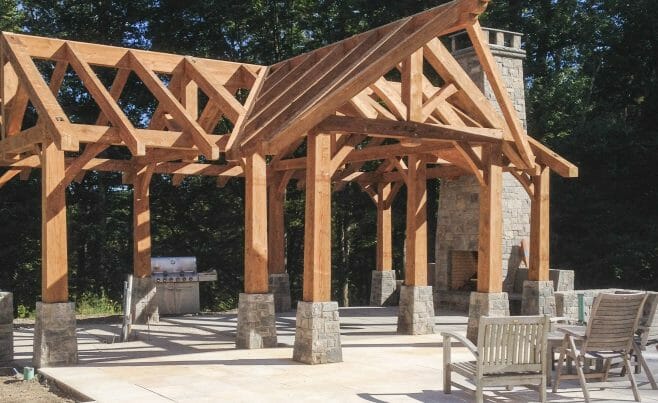 Pool House Timber Frame in CT. Pool patio with fireplace and rustic heavy timber pavilion.