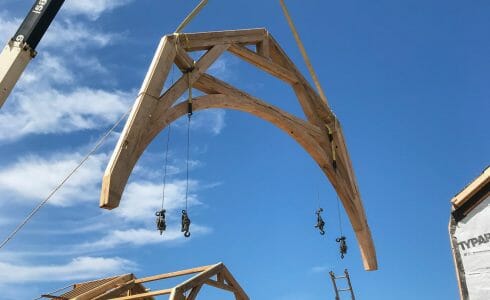 Lifting the reclaimed Oak Hammer Beam trusses by crane for the Seven Gates Residence in Martha's Vineyard