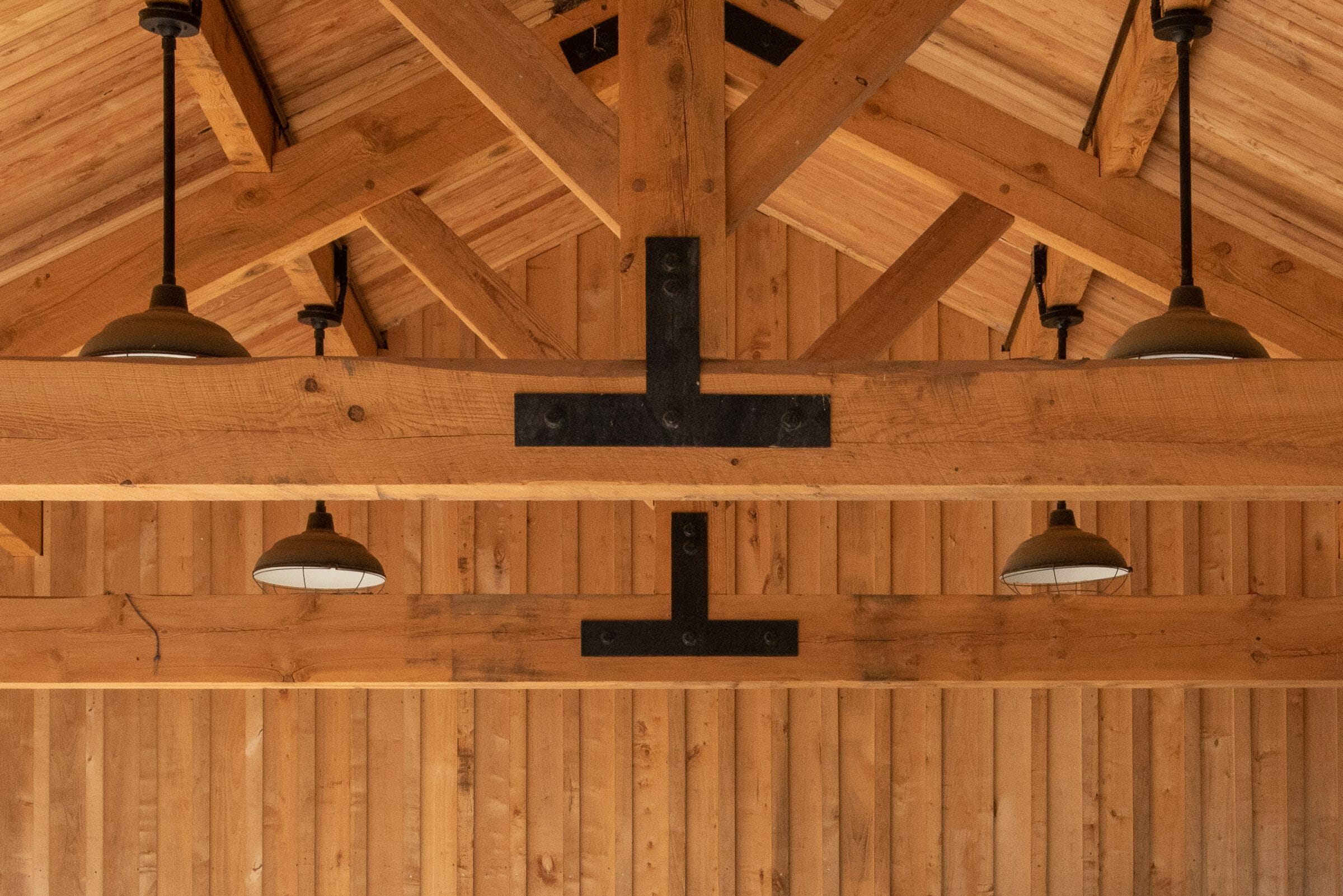 Timber Frame King Post Trusses with black steel plates in a pavilion at the Bechtel Summit home of the National Boy Scout Jamboree