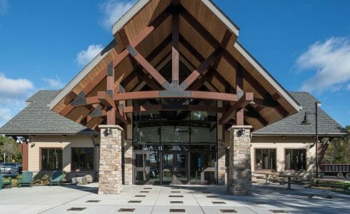 Exterior of the Adirondack Welcome Center in Queensbury, NY featuring Douglas fir Glulam Heavy Timber Trusses with steel plates.