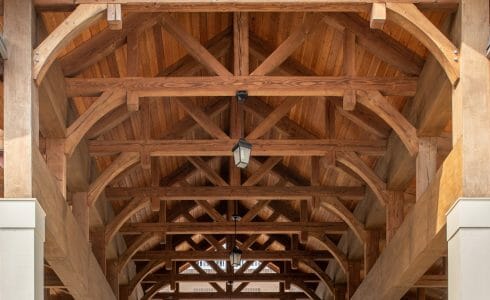 The Crossings at West Shore in Enola, PA. Timber Frame Porte Cochere Entry Way with Heavy Timber King Post Trusses and Stone Post Bases.