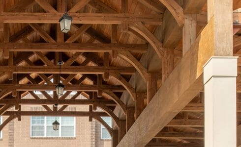 The Crossings at West Shore in Enola, PA. Timber Frame Porte Cochere Entry Way with Heavy Timber King Post Trusses and Stone Post Bases.