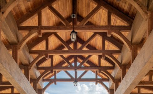 The Crossings at West Shore in Enola, PA. Timber Frame Porte Cochere Entry Way with Heavy Timber King Post Trusses and Stone Post Bases.