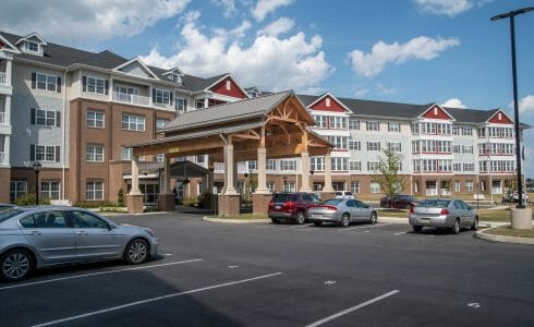 The Crossings at West Shore in Enola, PA. Timber Frame Porte Cochere Entry Way with Heavy Timber King Post Trusses and Stone Post Bases.