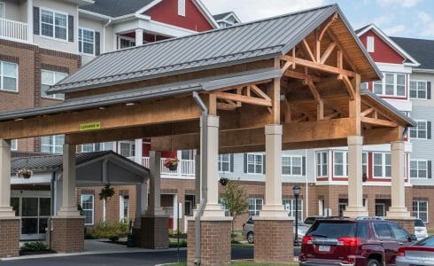 The Crossings at West Shore in Enola, PA. Timber Frame Porte Cochere Entry Way with Heavy Timber King Post Trusses and Stone Post Bases.