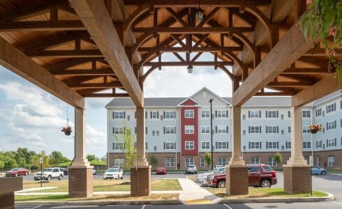 The Crossings at West Shore in Enola, PA. Timber Frame Porte Cochere Entry Way with Heavy Timber King Post Trusses and Stone Post Bases.