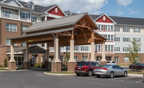 The Crossings at West Shore in Enola, PA. Timber Frame Porte Cochere Entry Way with Heavy Timber King Post Trusses and Stone Post Bases.