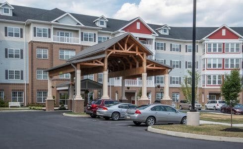 The Crossings at West Shore in Enola, PA. Timber Frame Porte Cochere Entry Way with Heavy Timber King Post Trusses and Stone Post Bases.