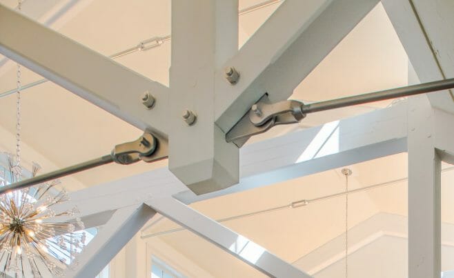 Steel tie bar and steel plate joinery details on a white timber truss in the Anya Restaurant in Thompson, CT.