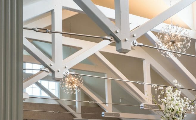 Steel tie bar and steel plate joinery details on a white timber truss in the Anya Restaurant in Thompson, CT.