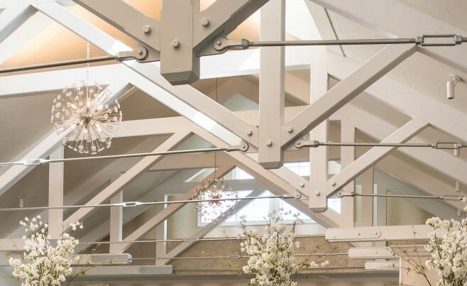 Steel tie bar and steel plate joinery details on a white timber truss in the Anya Restaurant in Thompson, CT.