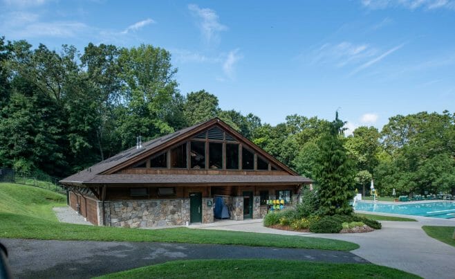 Exterior of the Katonah Pool house made with a heavy timber frame and trusses with stone post bases in Katonah New York.