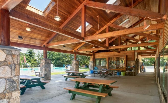 Interior of the Katonah Pool house made with a heavy timber frame and trusses with stone post bases in Katonah New York.