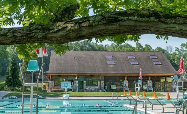 Exterior of the Katonah Pool house made with a heavy timber frame and trusses with stone post bases in Katonah New York.