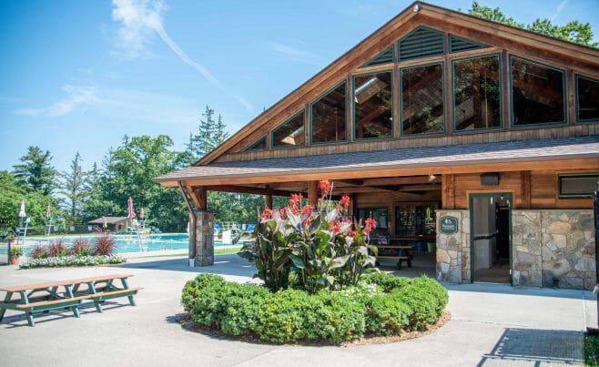 Exterior of the Katonah Pool house made with a heavy timber frame and trusses with stone post bases in Katonah New York.