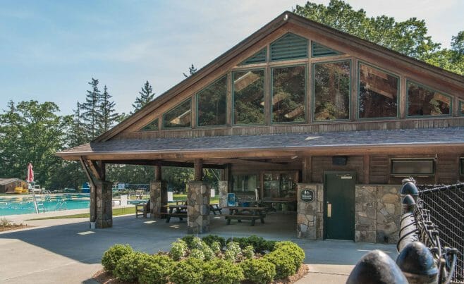 Exterior of the Katonah Pool house made with a heavy timber frame and trusses with stone post bases in Katonah New York.