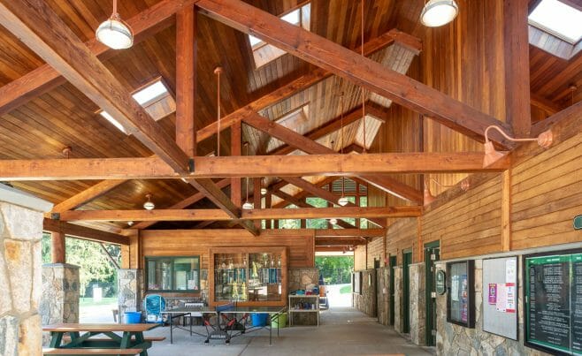 Interior of the Katonah Pool house made with a heavy timber frame and trusses with stone post bases in Katonah New York.