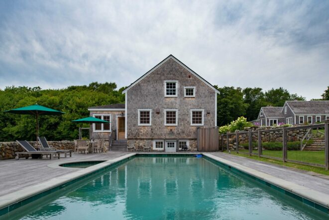 Exterior of a Guest Cottage Beach House in Martha's Vineyard overlooking the pool with traditional weathered Cedar siding