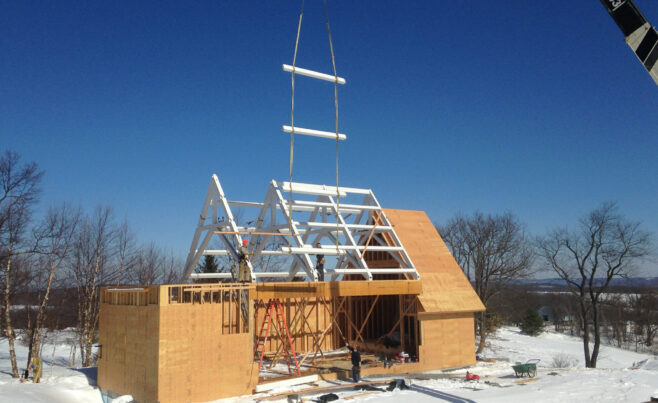 Scissor trusses with a dramatic pitch that have been stained white for a private chapel/pool building