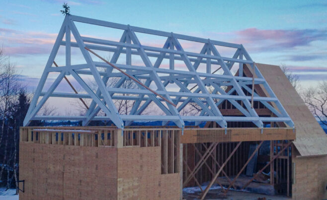 Scissor trusses with a dramatic pitch that have been stained white for a private chapel/pool building