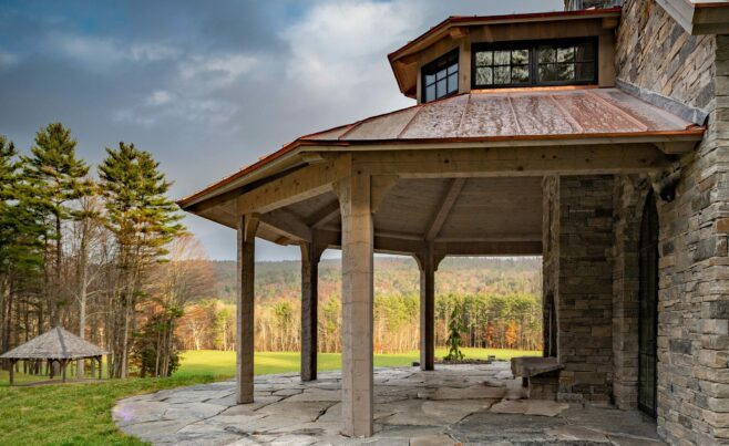 Exterior of a home in New Hampshire with a Hand Hewn Timber Framed Loggia or attached outdoor entertainment area