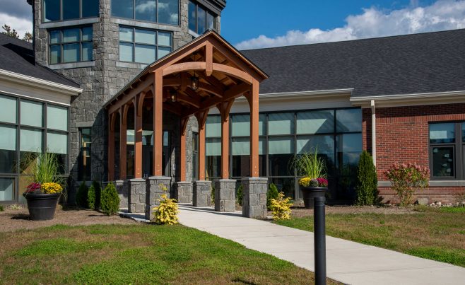 Front view of the school entryway with arched timber trusses.